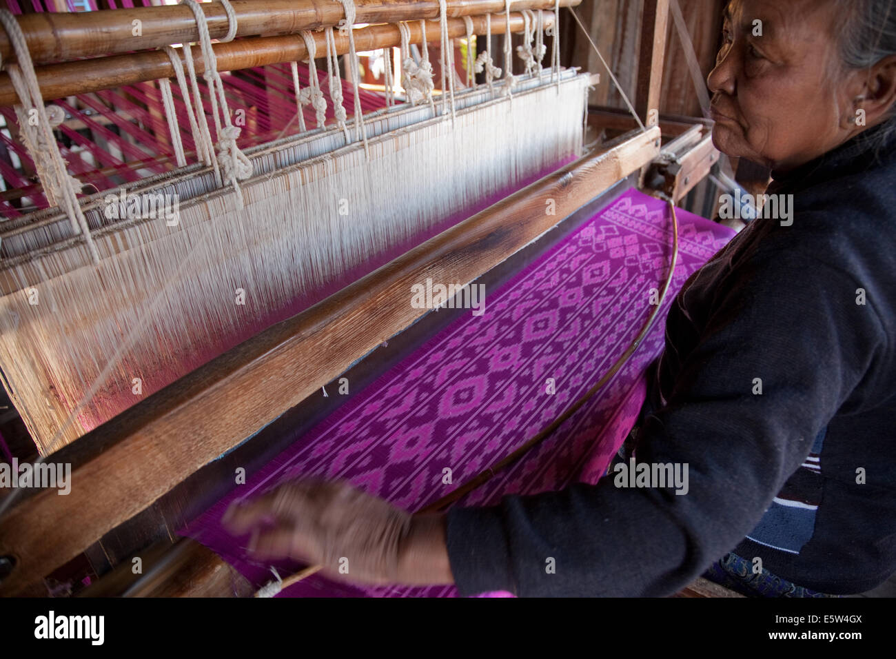 Woman weaving silk cloth on a hand-operated loom, In Phaw Khone village, Shan state, Myanmar (Burma). Stock Photo