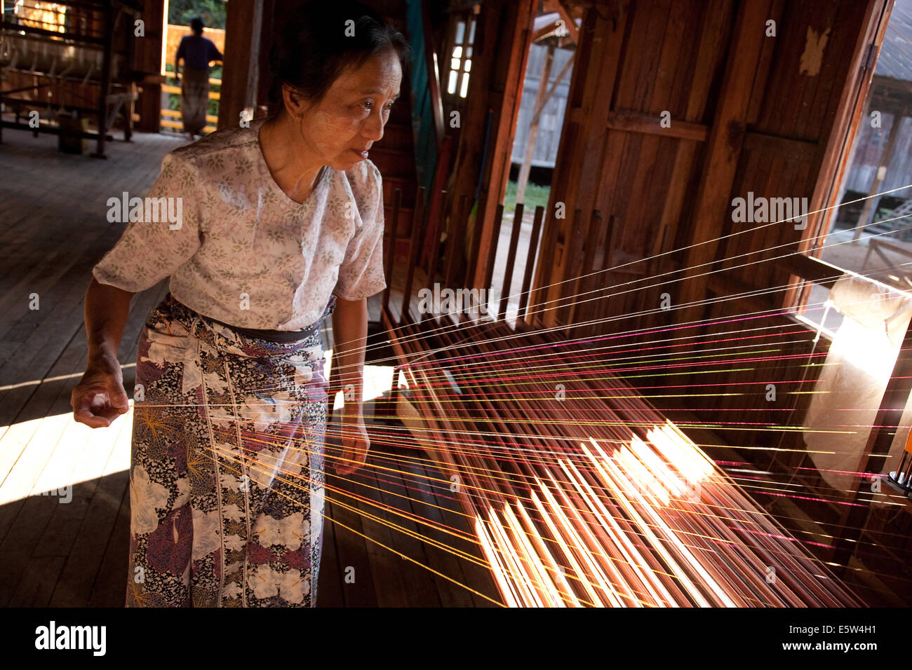 Woman holding silk threads in a weaving In Phaw Khone village
