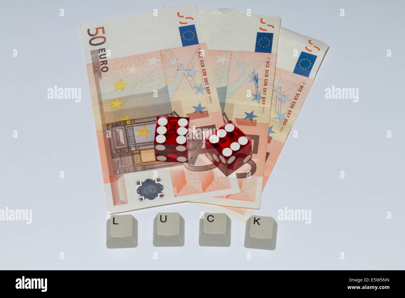 Two dices showing '6', three Euro notes and writing 'LUCK', formed by the keys of a keyboard Stock Photo