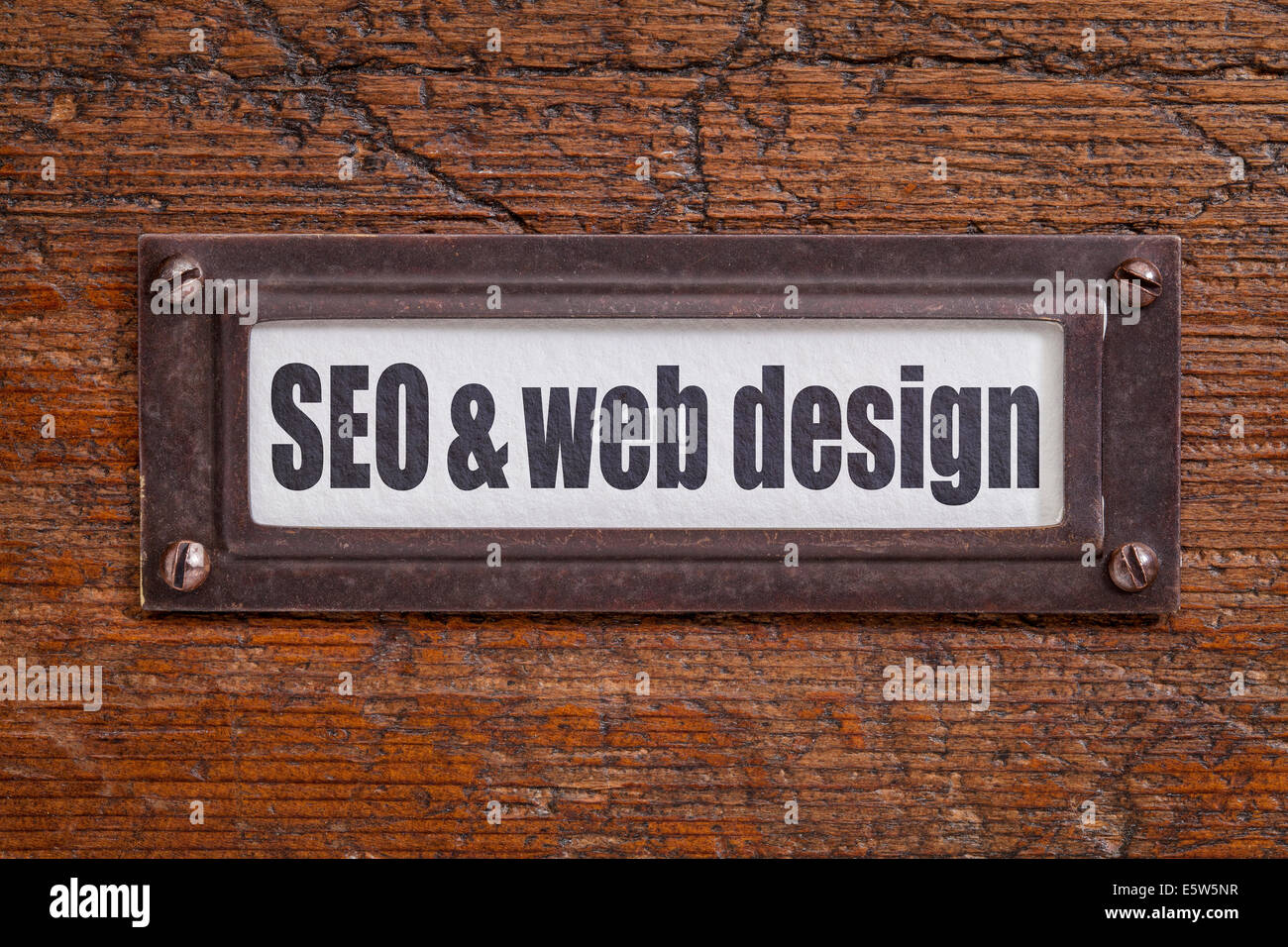 SEO and web design  - file cabinet label, bronze holder against grunge and scratched wood Stock Photo