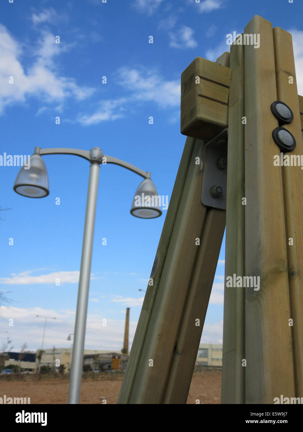 Part of a playground swing in the foreground and a street light in the