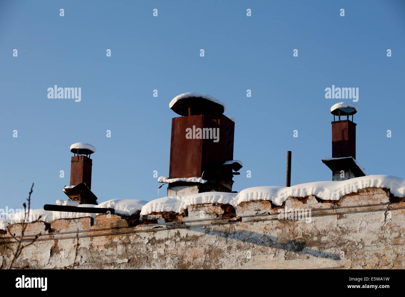 Snow covered rusty chimney pots industrial Stock Photo