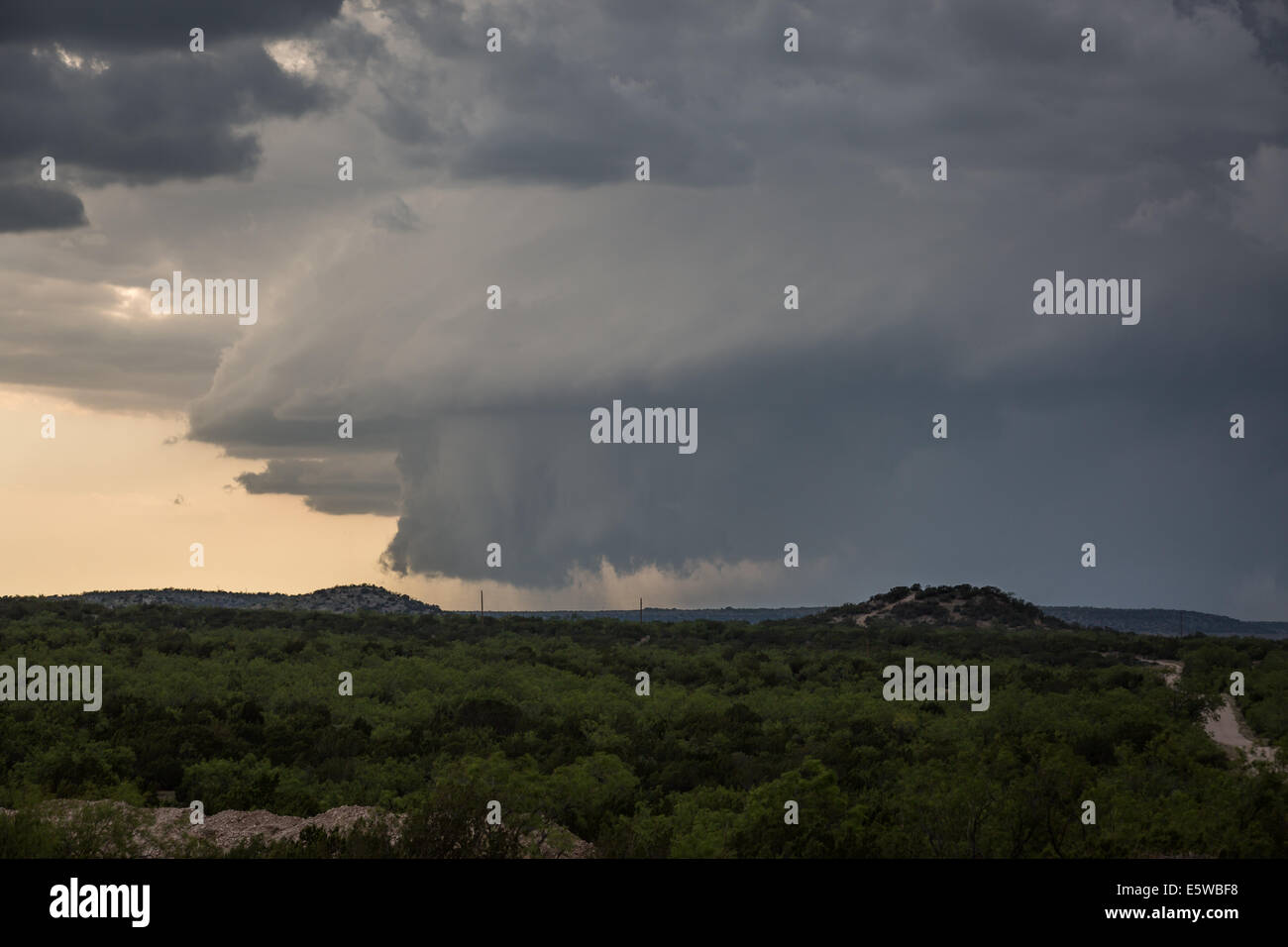 A powerful tornado warned supercell thunderstorm with a large wall cloud dominates the Texas sky while producing severe weather Stock Photo