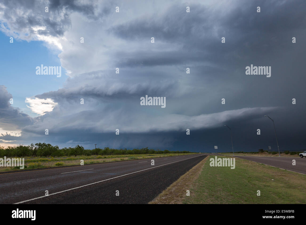A powerful tornado warned supercell thunderstorm with a large wall cloud dominates the Texas sky while producing severe weather Stock Photo