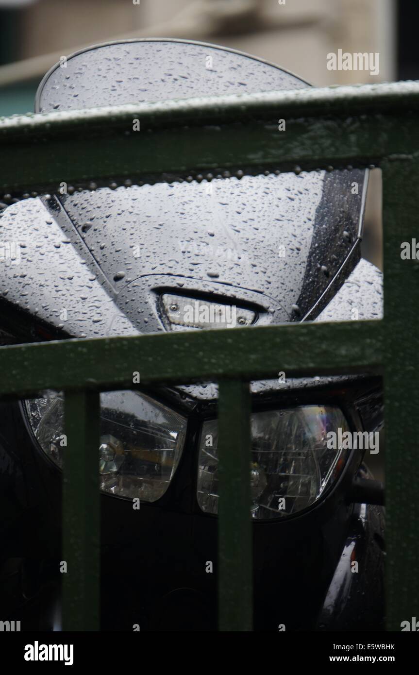 Paris in the rain, front view of the windshield and headlight of a motorcycle Stock Photo