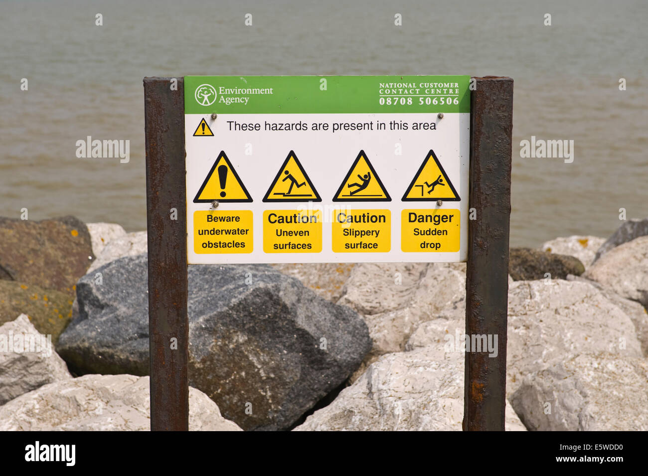 Environment Agency hazard warning sign on seawall at Reculver Herne Bay Kent England UK Stock Photo