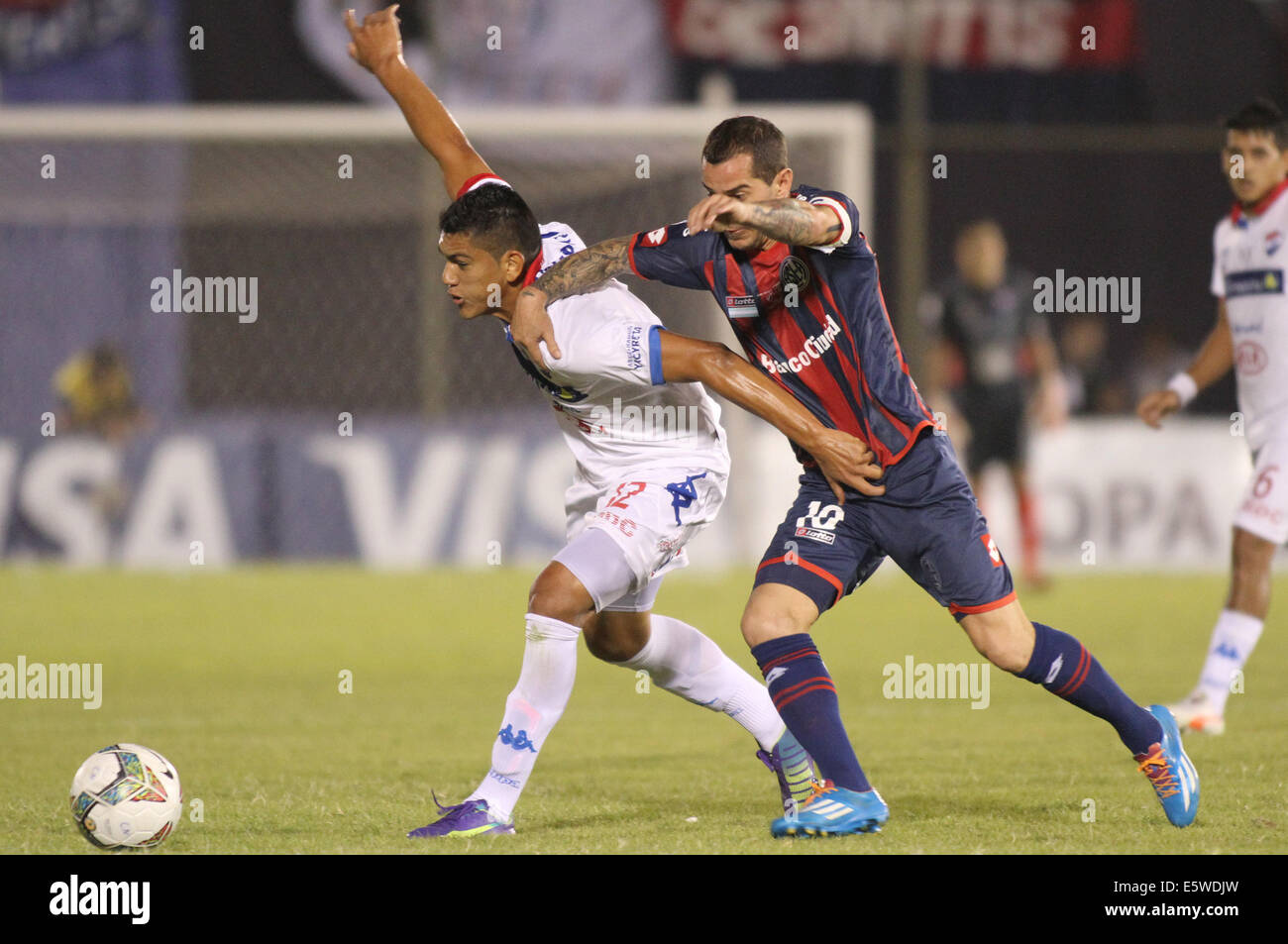 Asuncion, Paraguay. 6th Aug, 2014. Nacional's Ramon Coronel(L) vies for the ball with Leandro Romagnoli(R) of San Lorenzo during their first-leg final match of the 2014 Libertadores Cup at Defensores del Chaco Stadium, in Asuncion, Paraguay, on Aug. 6, 2014. Credit:  Str/Xinhua/Alamy Live News Stock Photo