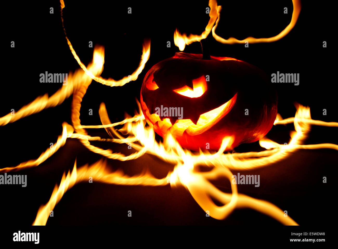 Burning halloween pumpkin on black background Stock Photo - Alamy
