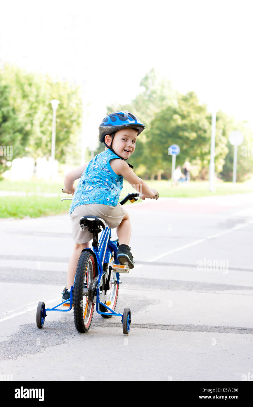 Baby boy on bike with crash helmet Stock Photo