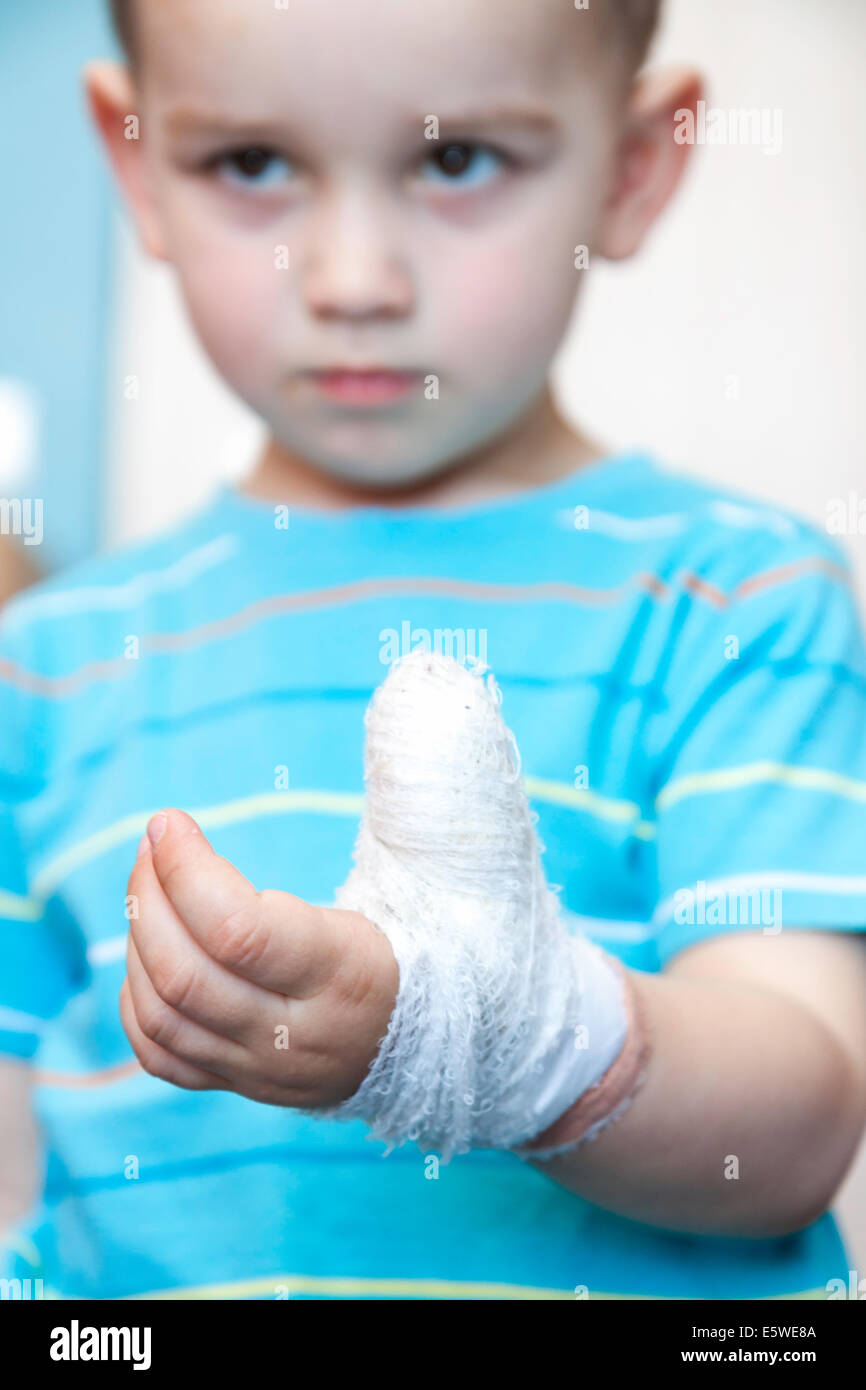 wounded in the left hand with bandage boy at shot in home Stock Photo
