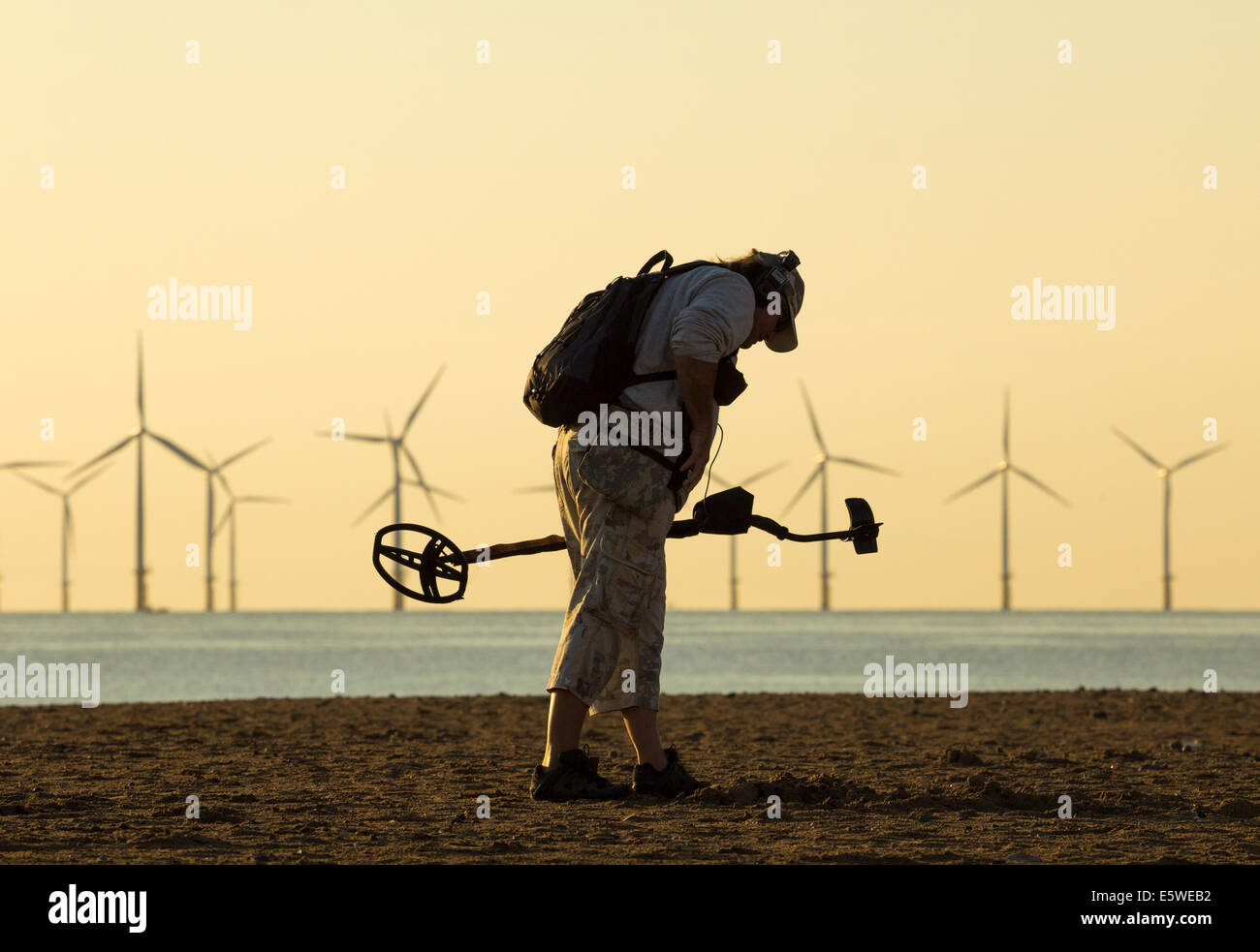 Man metal detecting with metal detector on beach. UK Stock Photo Alamy