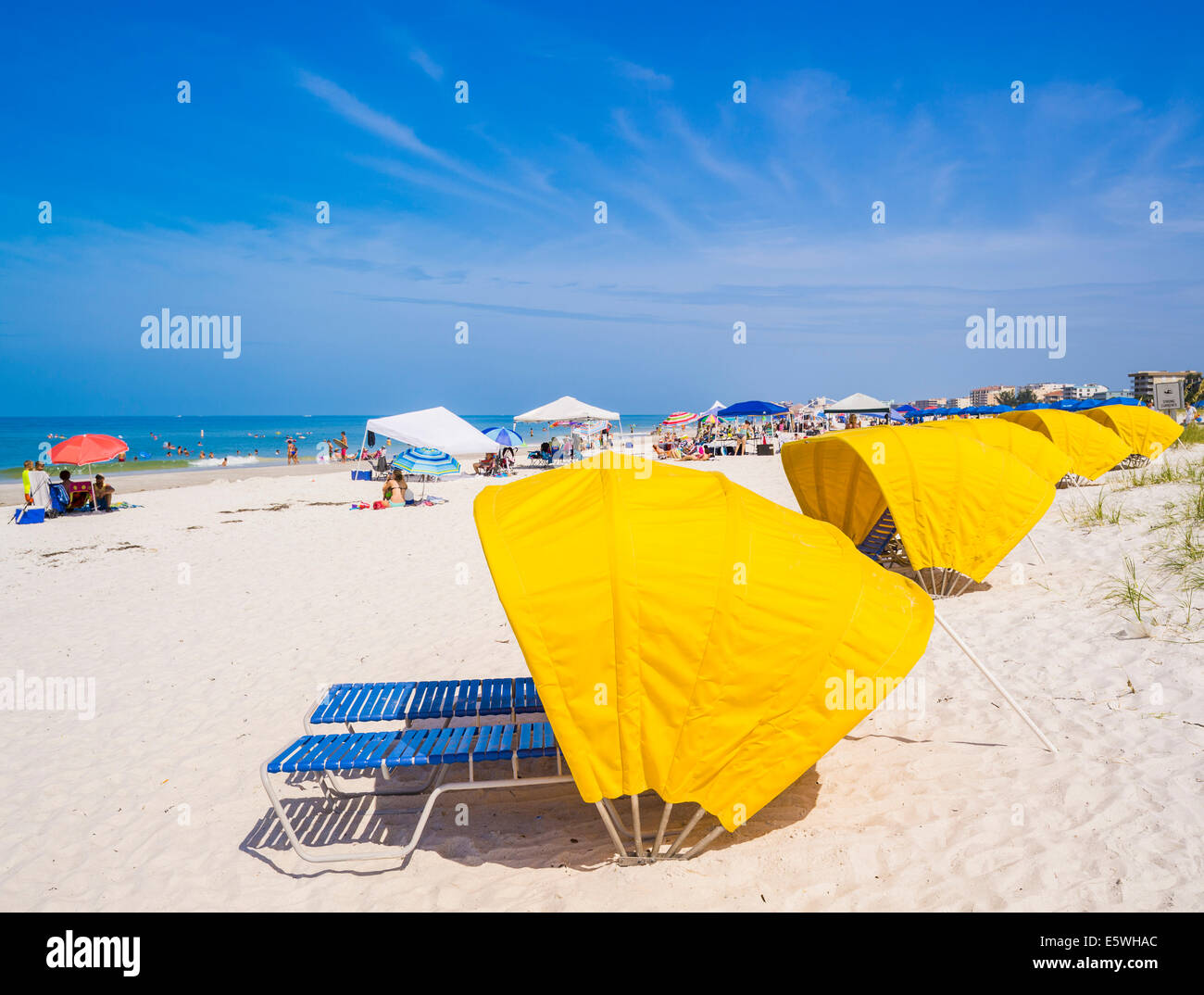 Florida beach - People sunbathing and rows of sunbeds with bright yellow shades on the beautiful Madeira Beach in Florida, USA Stock Photo