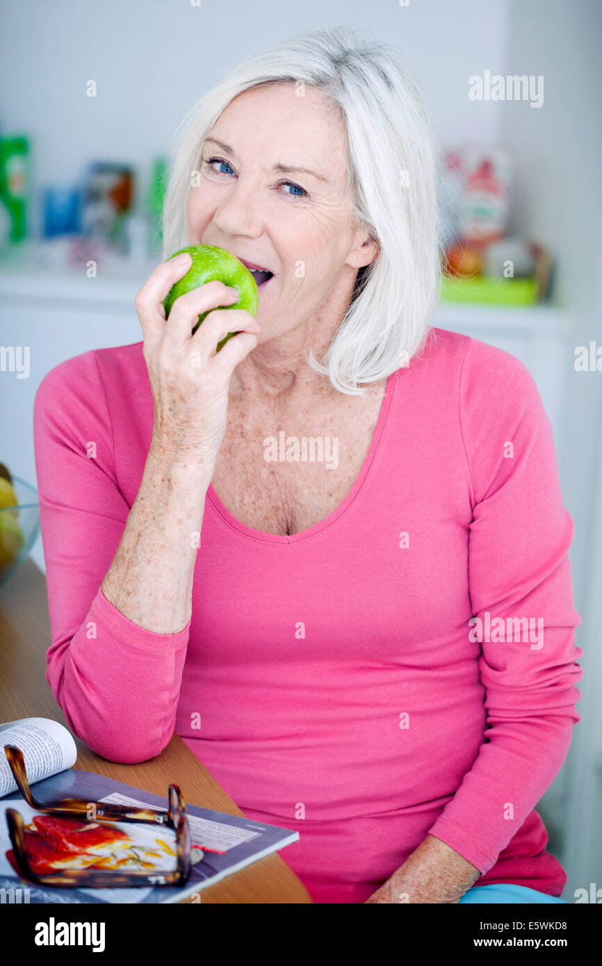 Elderly person eating fruit Stock Photo