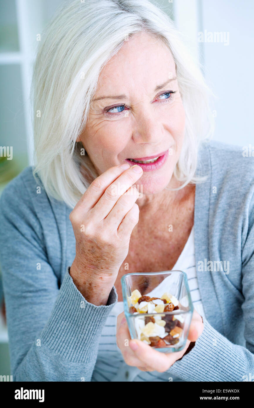 Elderly person eating dried fruit Stock Photo
