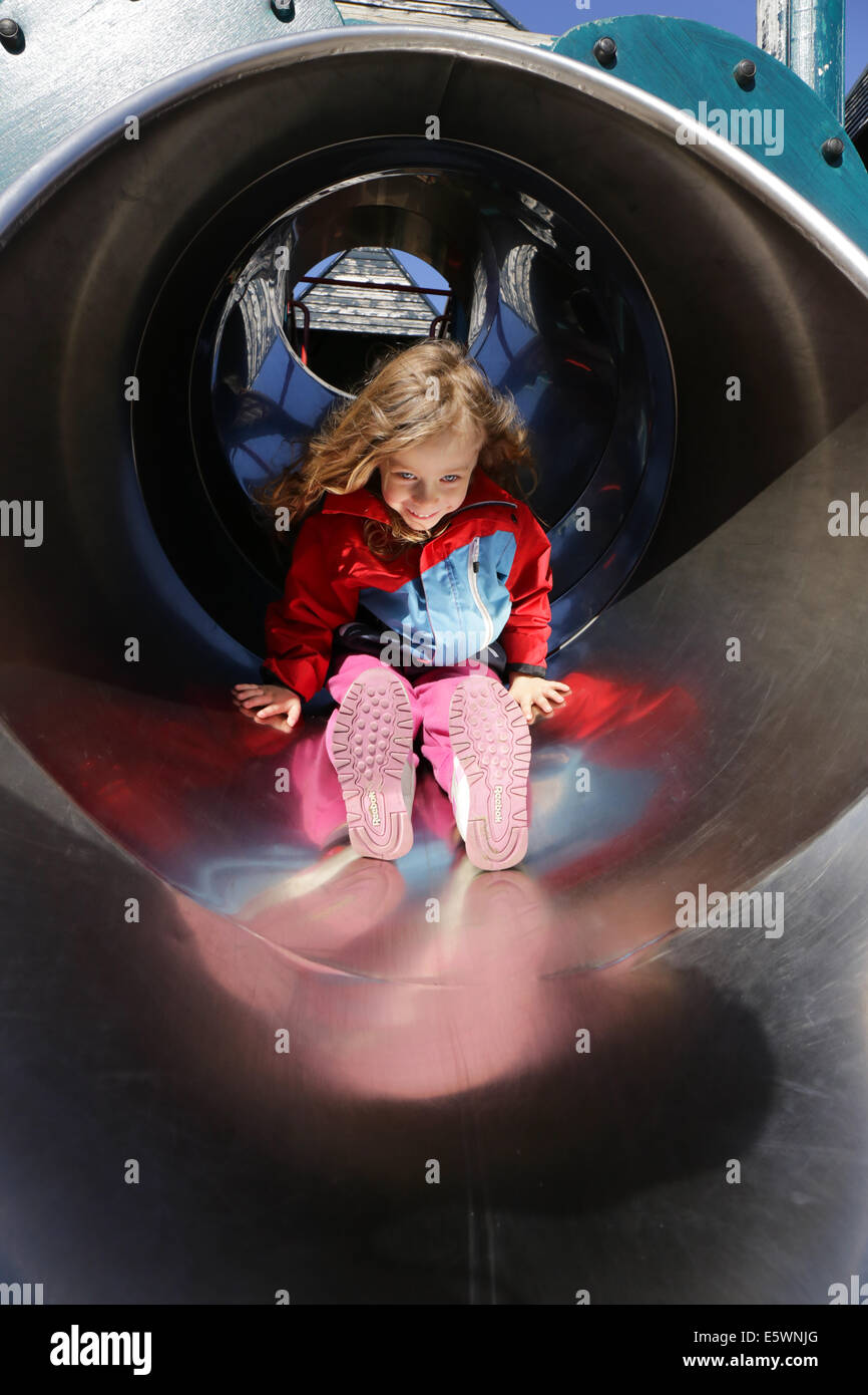 Girl in a slide at a playground Stock Photo - Alamy