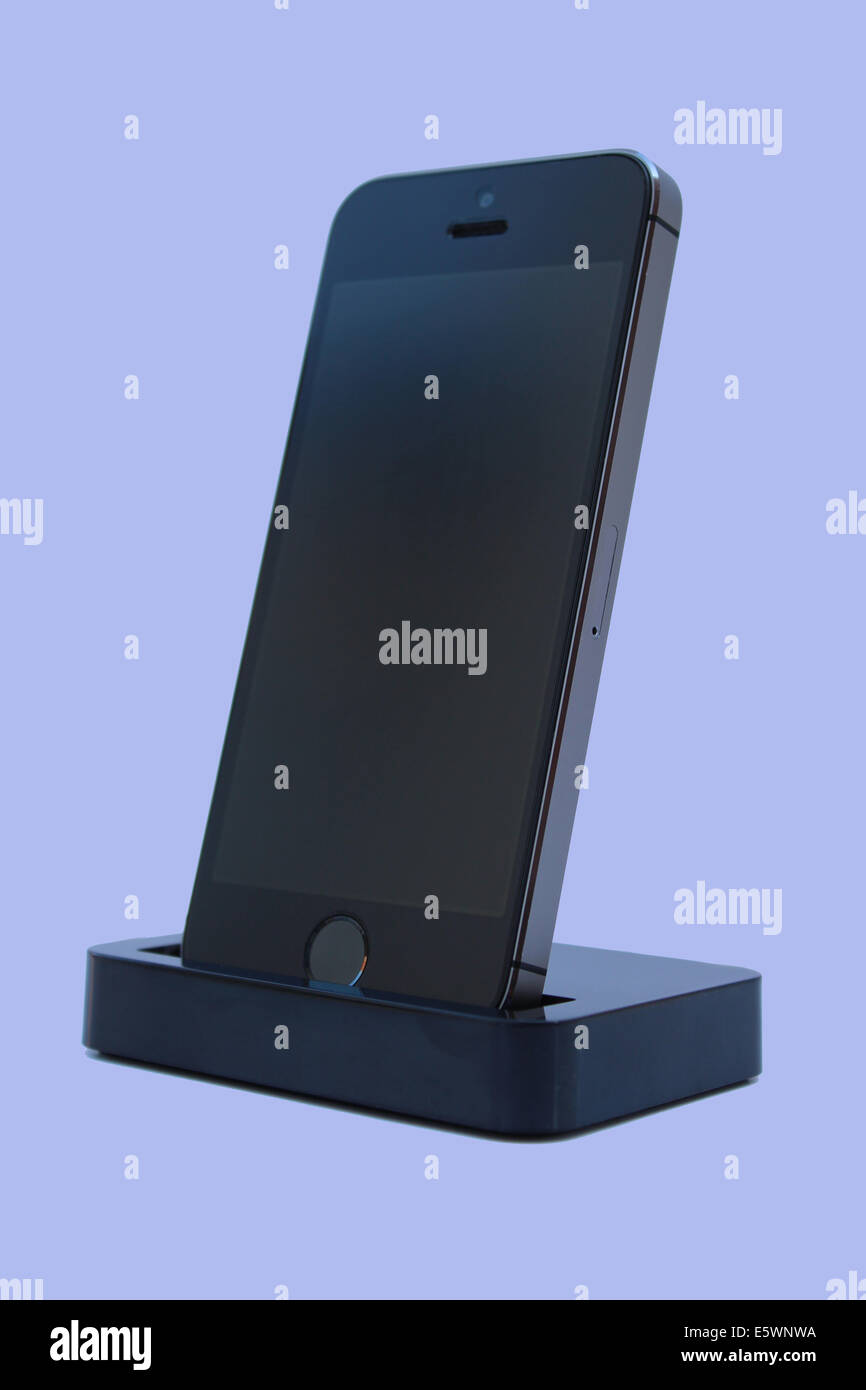 A black iPhone 5s displayed on a charging dock Stock Photo
