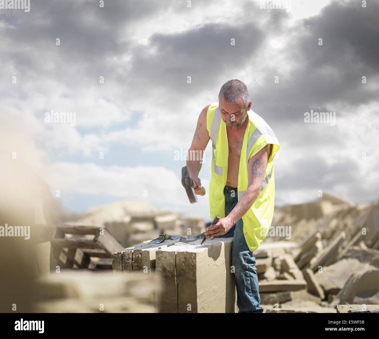 Quarry worker shaping sandstone in Yorkshire stone quarry Stock Photo