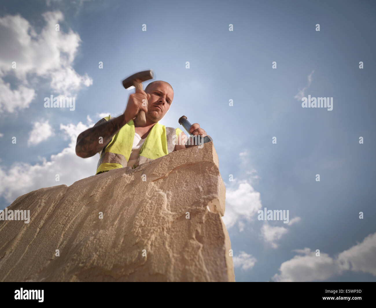 Quarry worker splitting sandstone in Yorkshire stone quarry Stock Photo