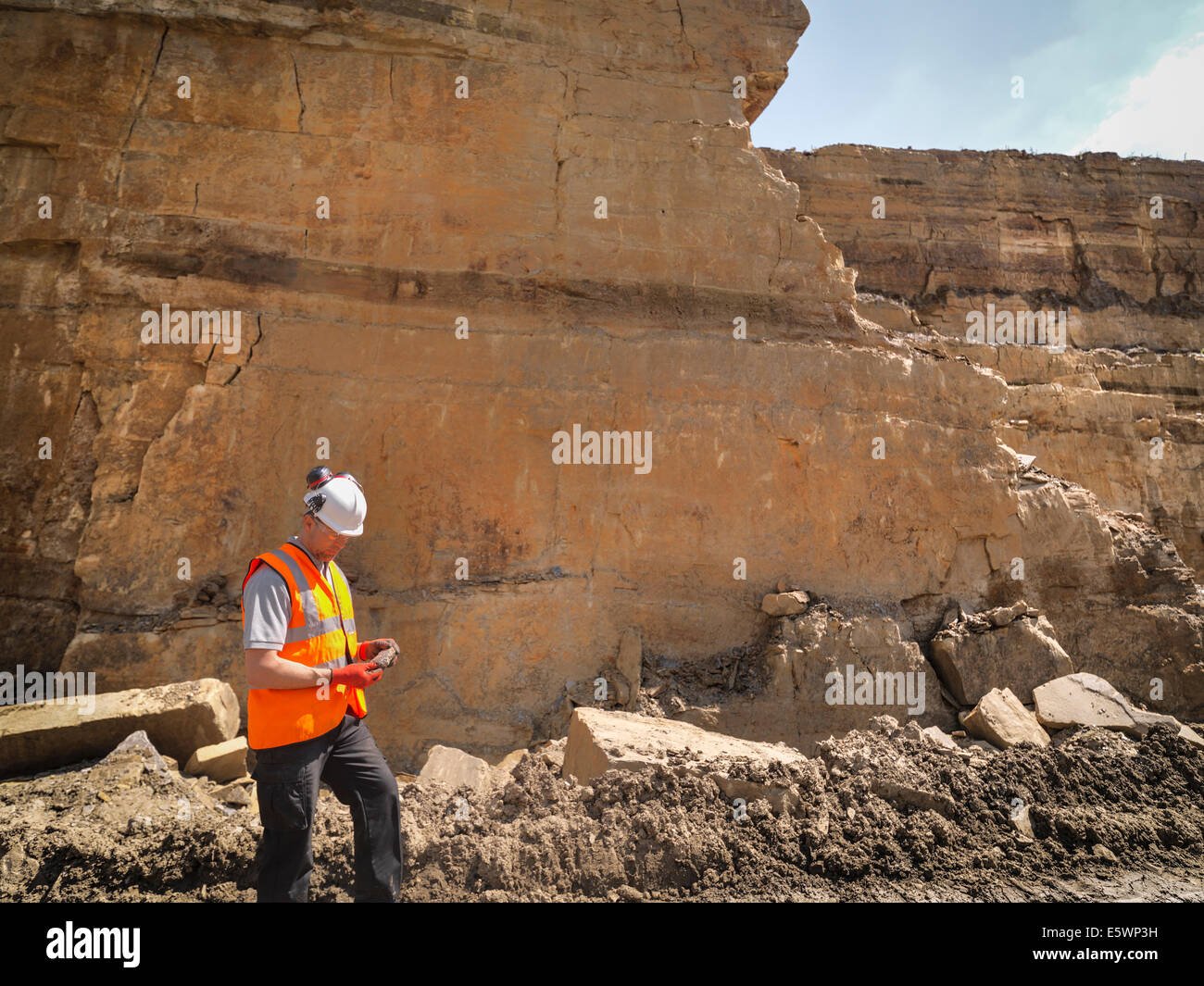 Quarry worker inspecting stone in quarry Stock Photo