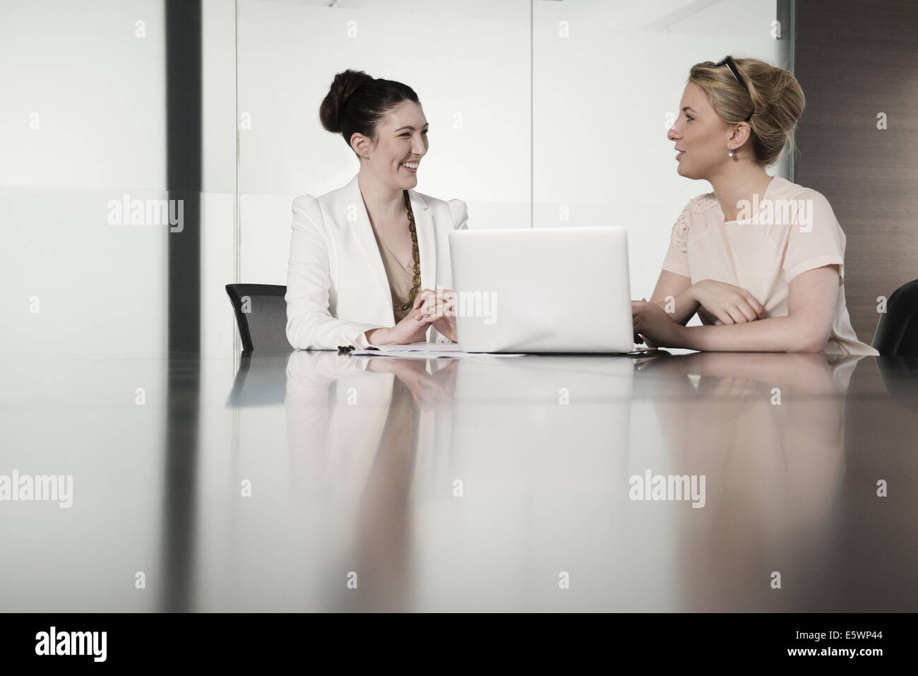 Two young businesswomen having face to face meeting in conference room Stock Photo