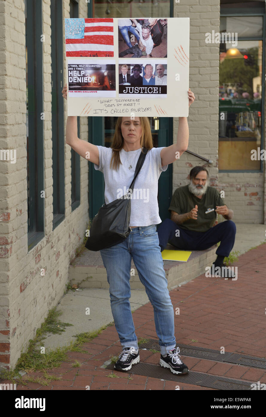 Huntington, New York, USA. 6th Aug, 2014. A protestor holds a sign with ''3 times help requested, 3 times help denied'' about the bombing in Benghazi that resulted in death of U.S. Ambassador Stevens and 3 other Americans, as she stand outside the Book Revue where H. Clinton will have a book signing for her new memoir, Hard Choices at 6pm. Clinton's book is about her four years as America's 67th Secretary of State and how they influence her view of the future. Credit:  Ann Parry/ZUMA Wire/Alamy Live News Stock Photo