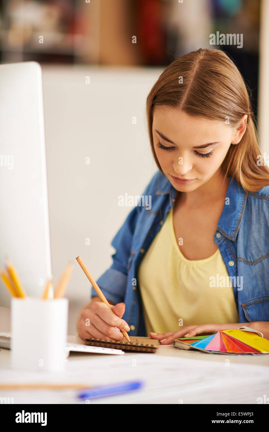 Portrait of pretty student of design faculty making sketch at lesson Stock Photo