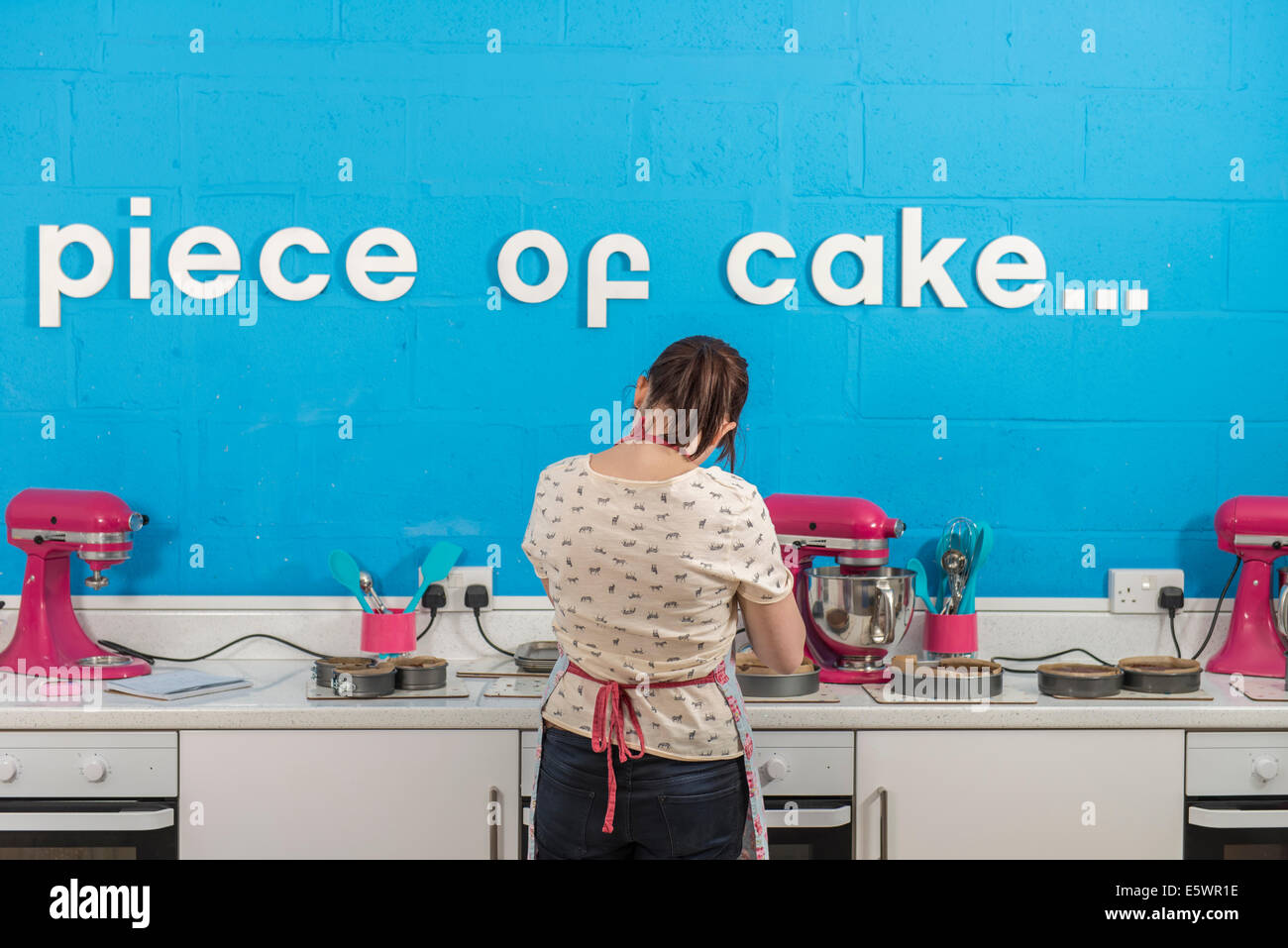 Rear view of young woman using blender in bakery Stock Photo