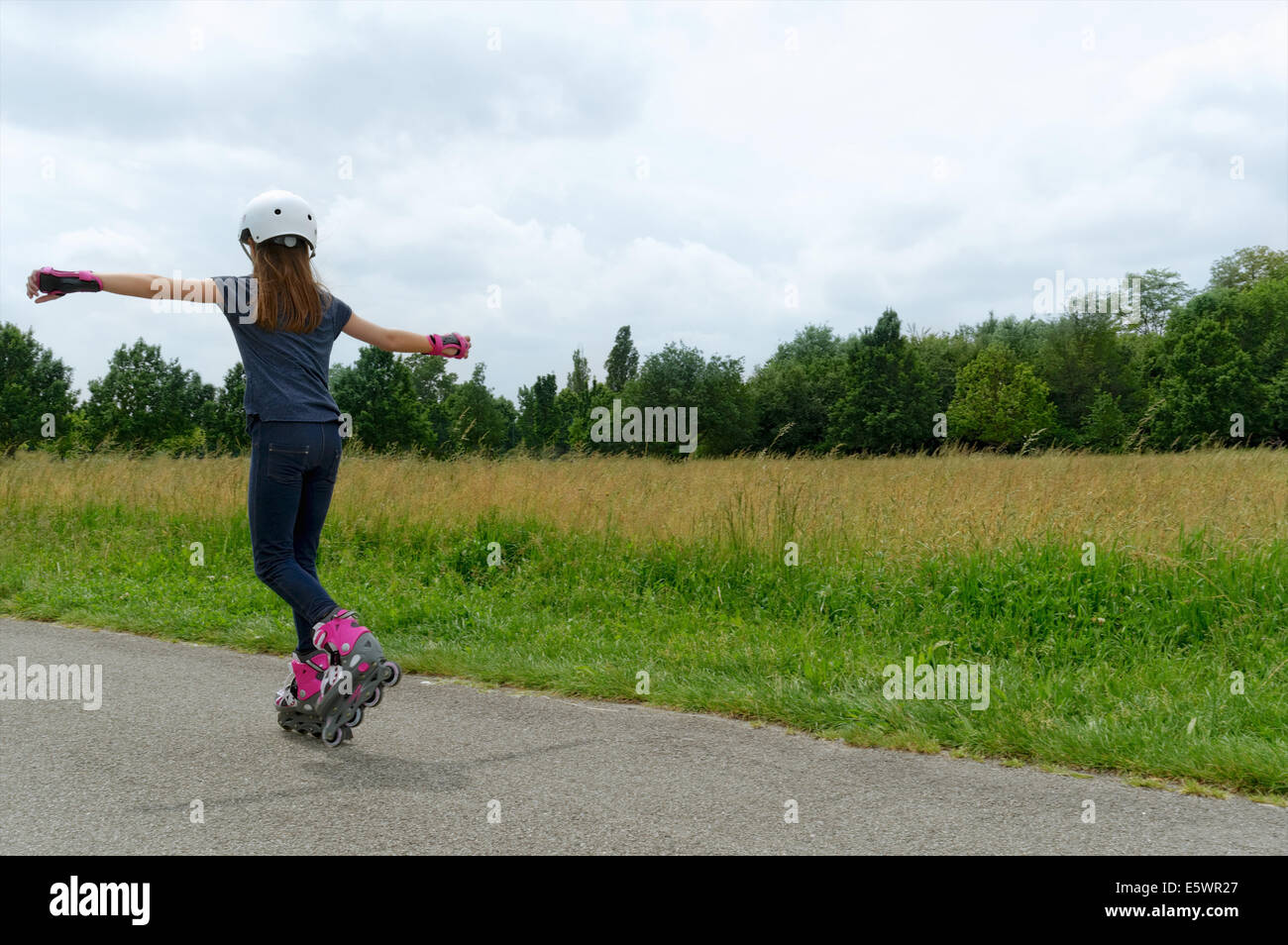 Rear view of girl rollerblading in park Stock Photo