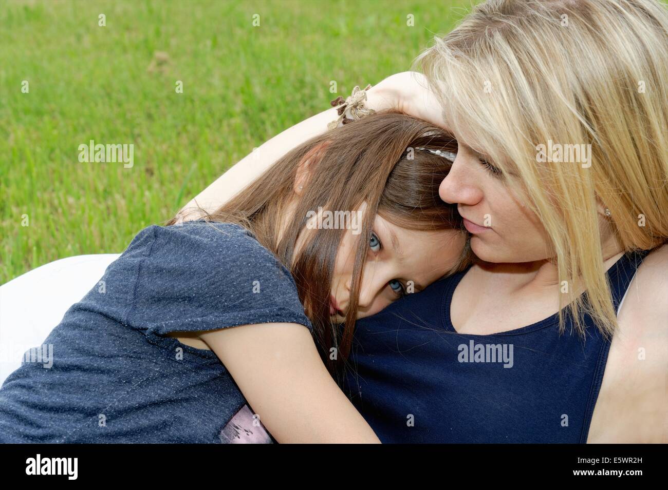 Close up of girl and mother hugging in park Stock Photo