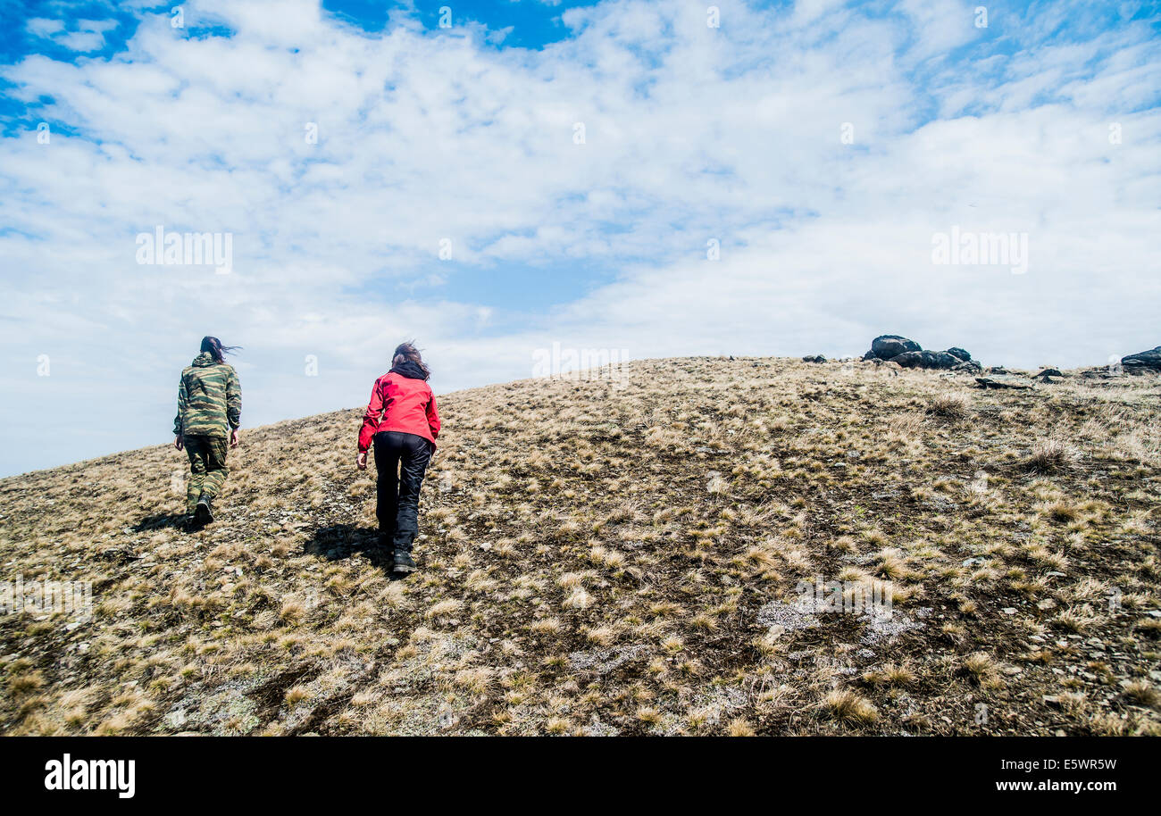 Rear view of two young women hiking up mountain Stock Photo - Alamy