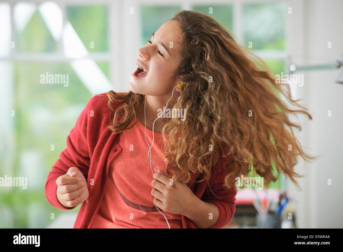 Young girl wearing headphones, dancing to music Stock Photo