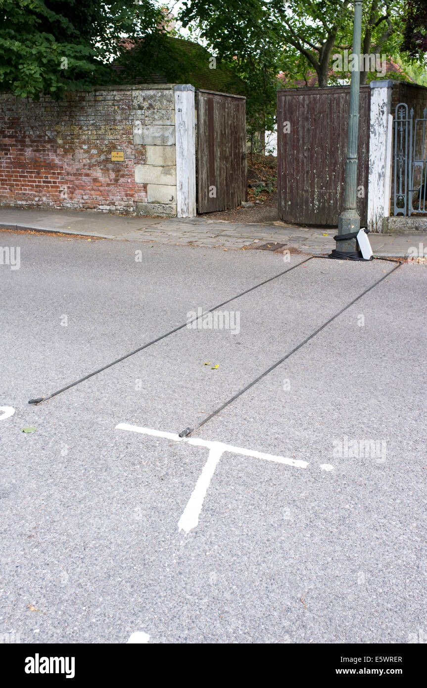 Sensor cables from traffic data recording device stretched across UK road Stock Photo