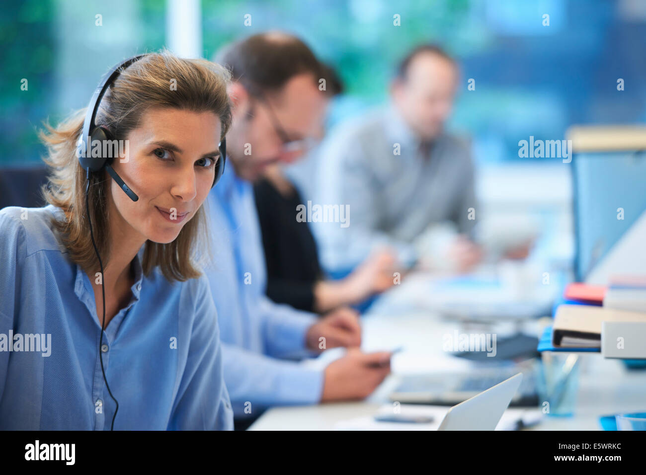Woman wearing telephone headset in office Stock Photo