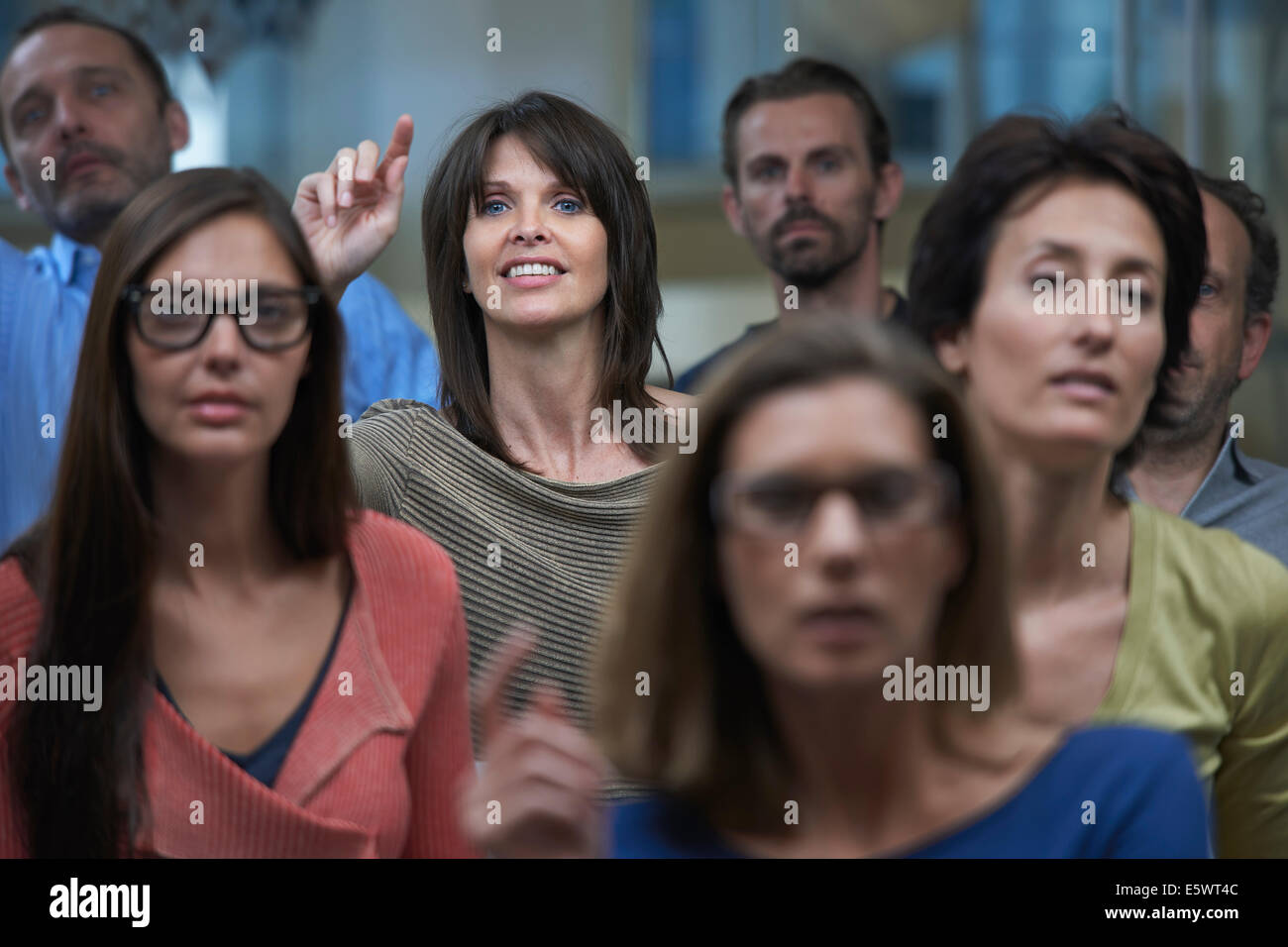 Group watching presentation, woman raising hand Stock Photo