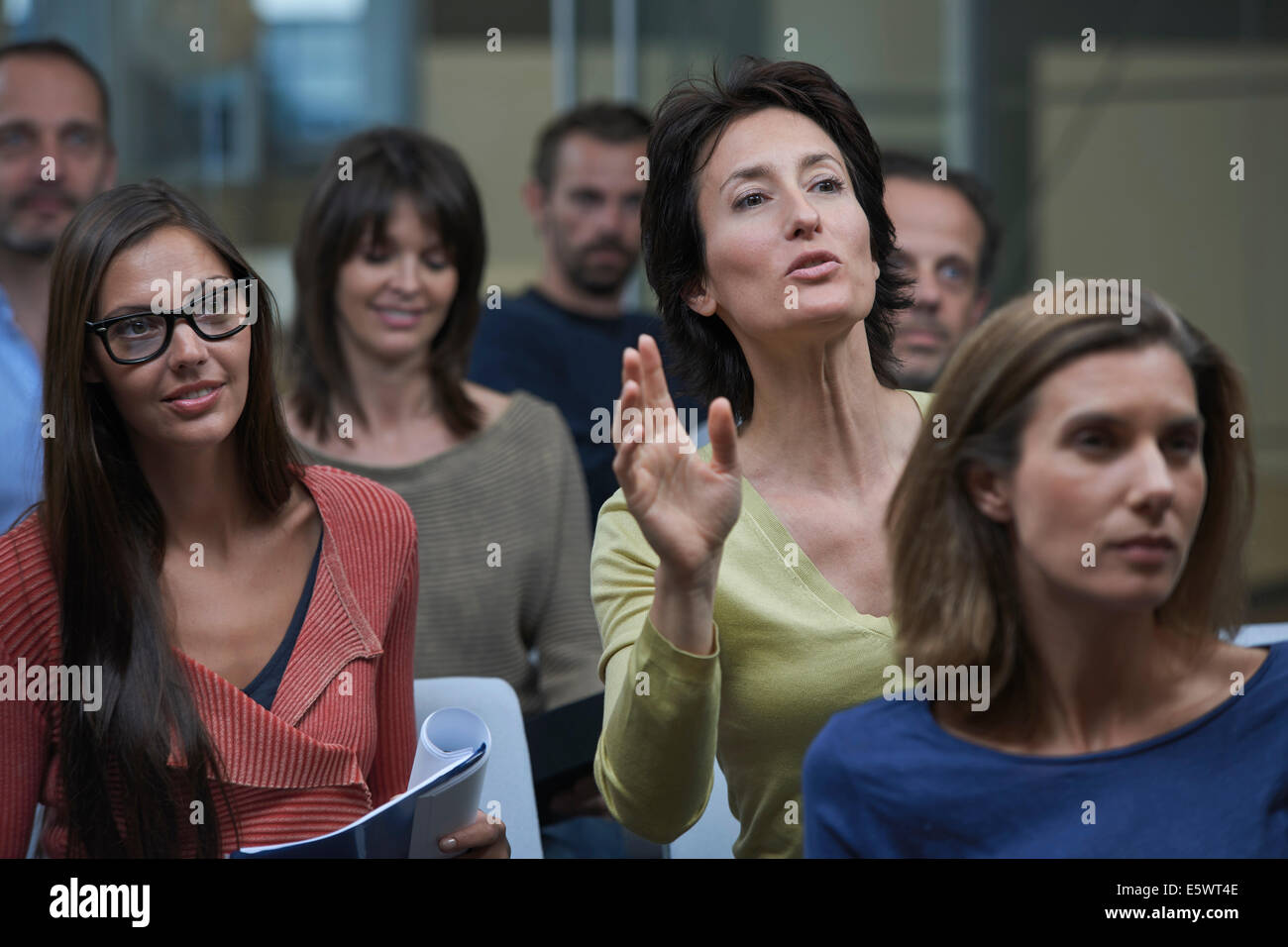 Group watching presentation, woman raising hand Stock Photo