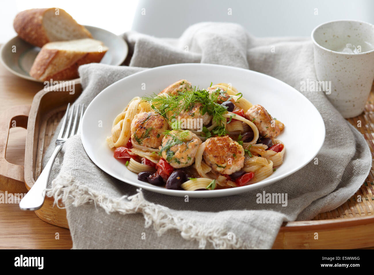 Bowl of linguine and salmon polpette with herb garnish Stock Photo