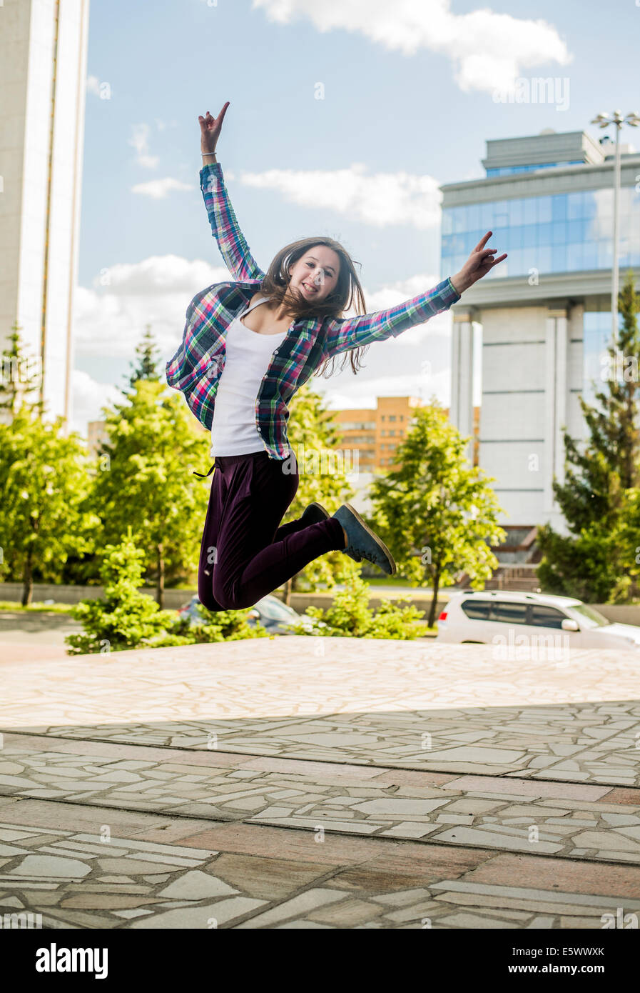 Young woman jumping mid air in city Stock Photo