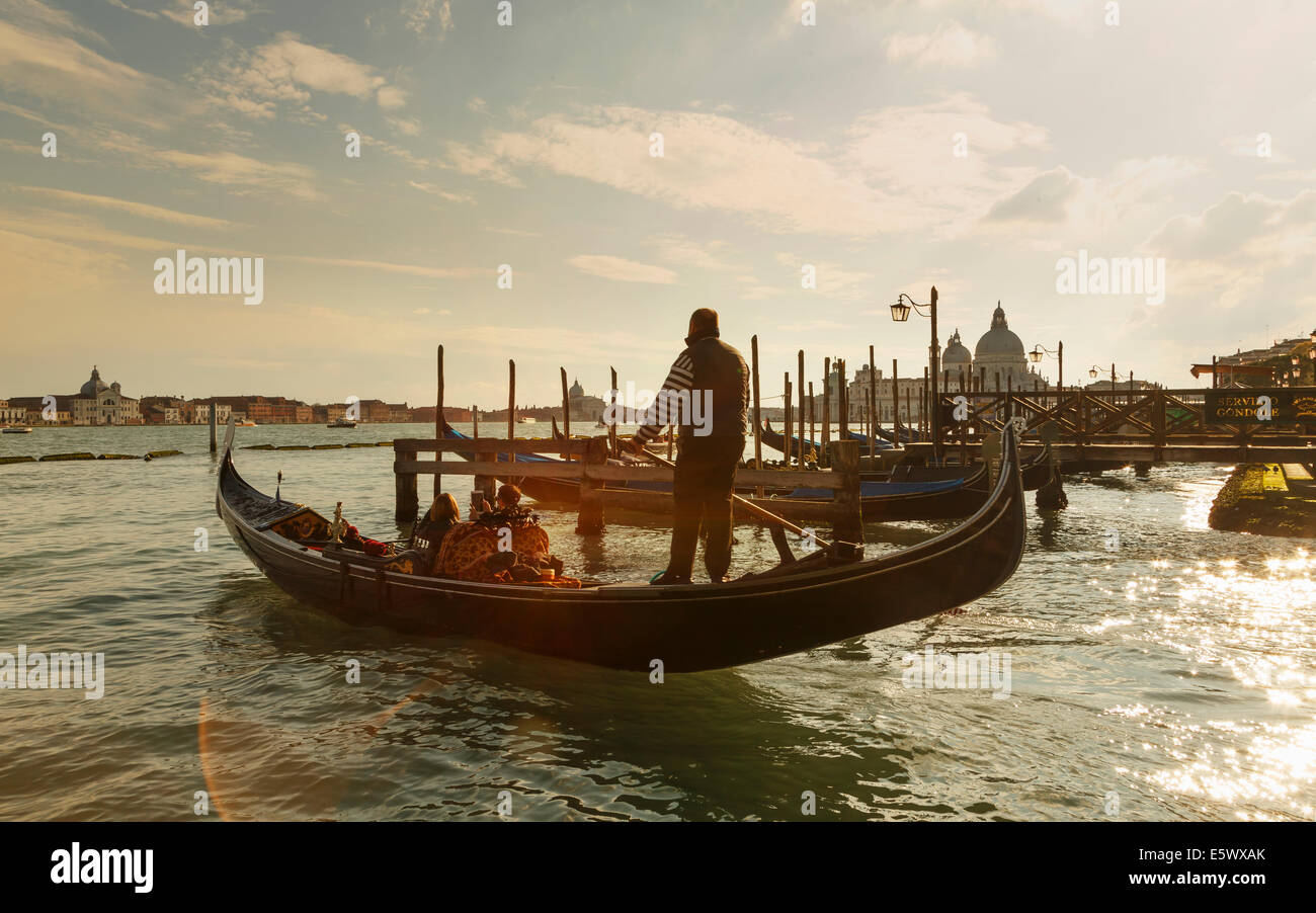 Silhouetted view of gondolier at sunset, Venice, Veneto, Italy Stock Photo