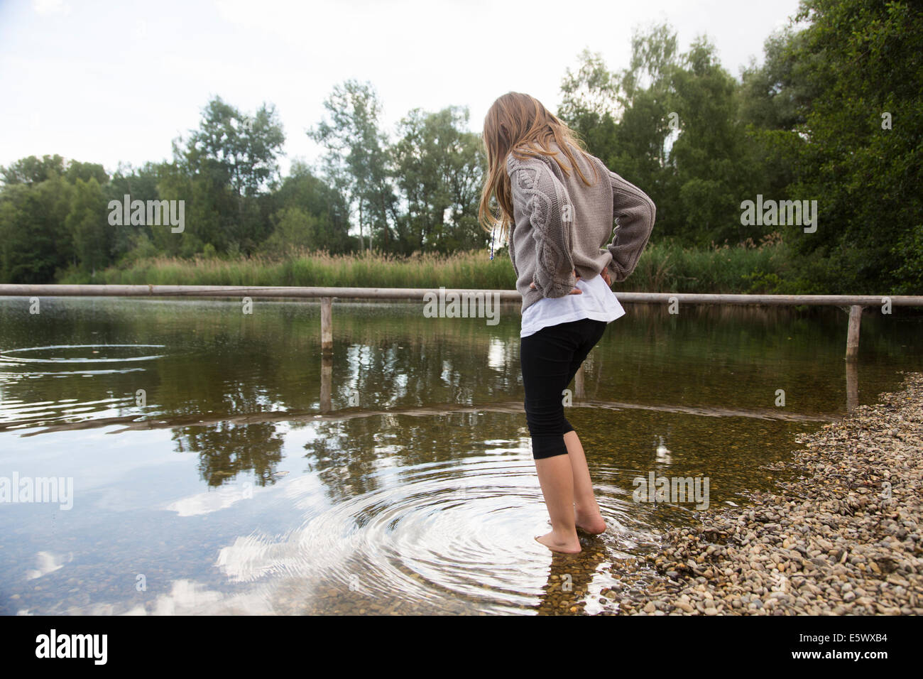 Girl paddling and looking down at lake Stock Photo