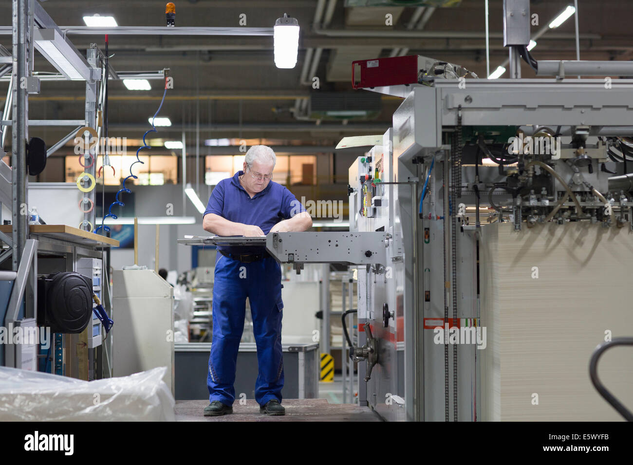 Worker using machine in paper packaging factory Stock Photo Alamy