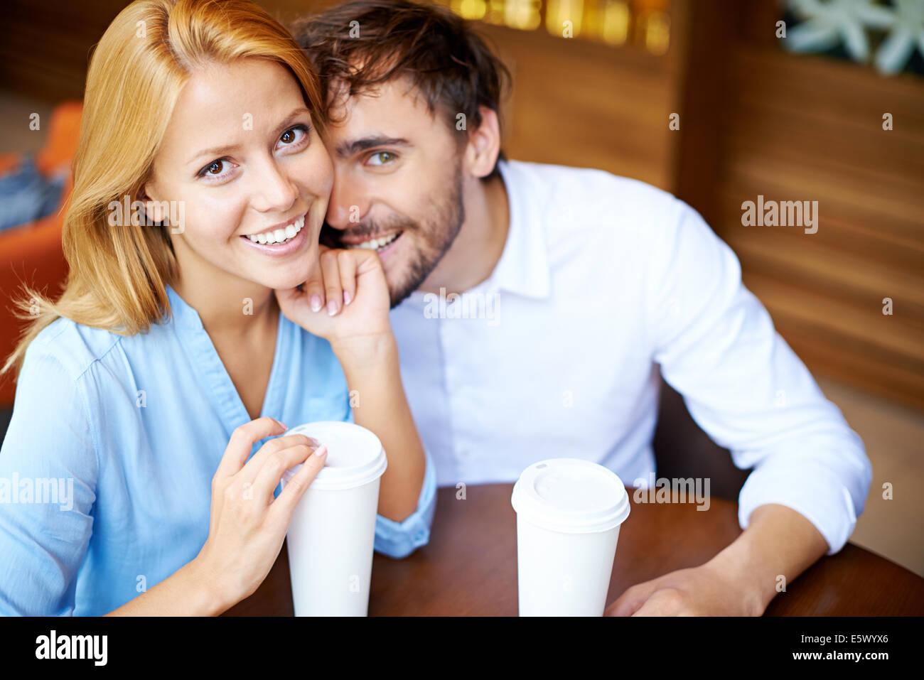 Portrait of young couple sitting by table in cafe Stock Photo