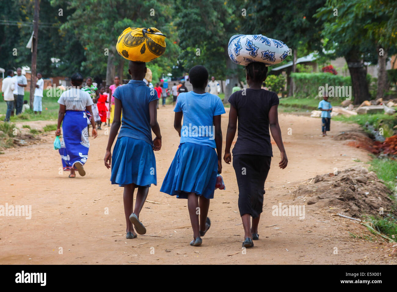 The African way. Two young women carry items on their heads, in the tourist resort of Nkhata Bay. Stock Photo