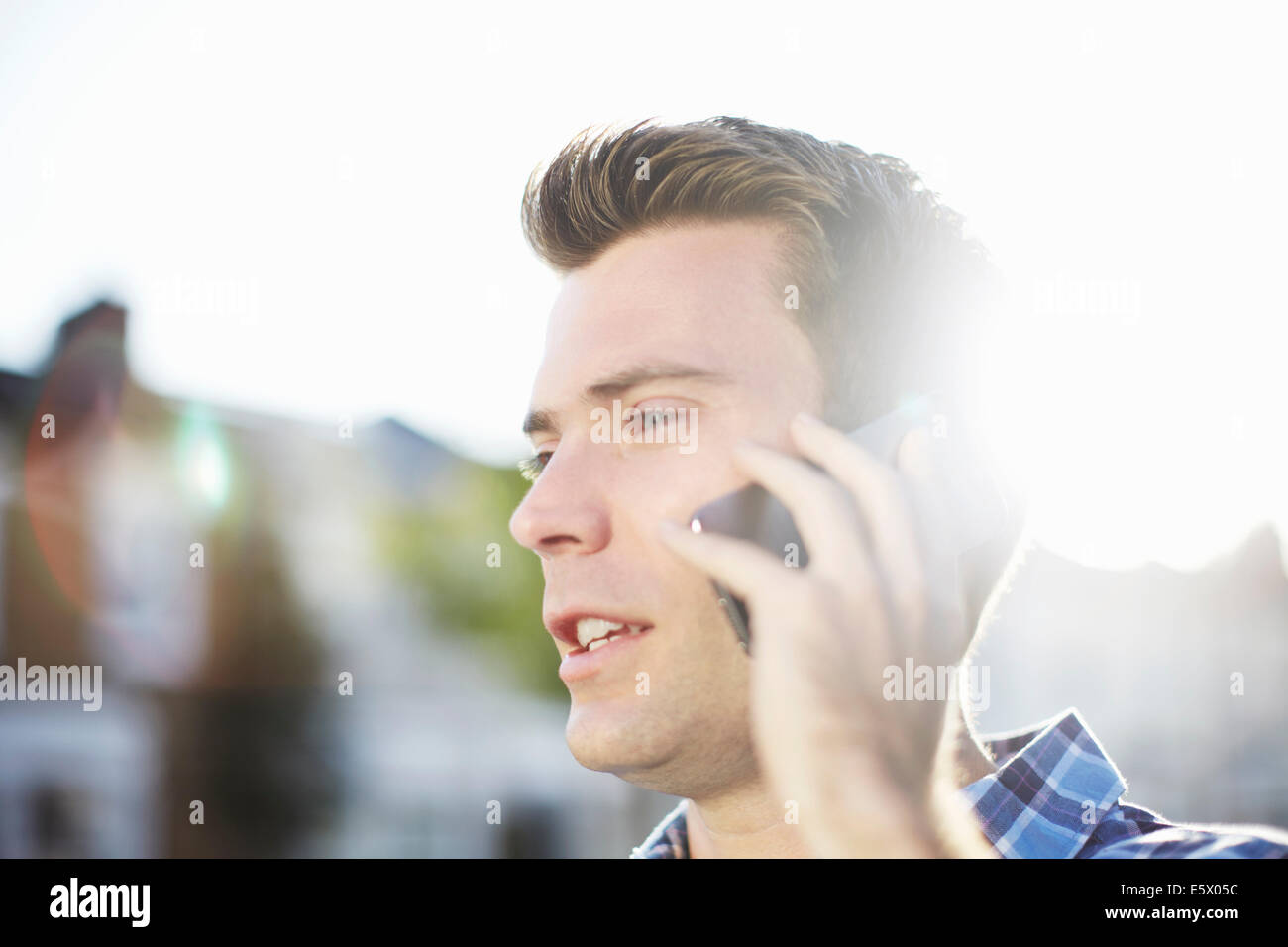 Mid adult man talking on smartphone on street Stock Photo