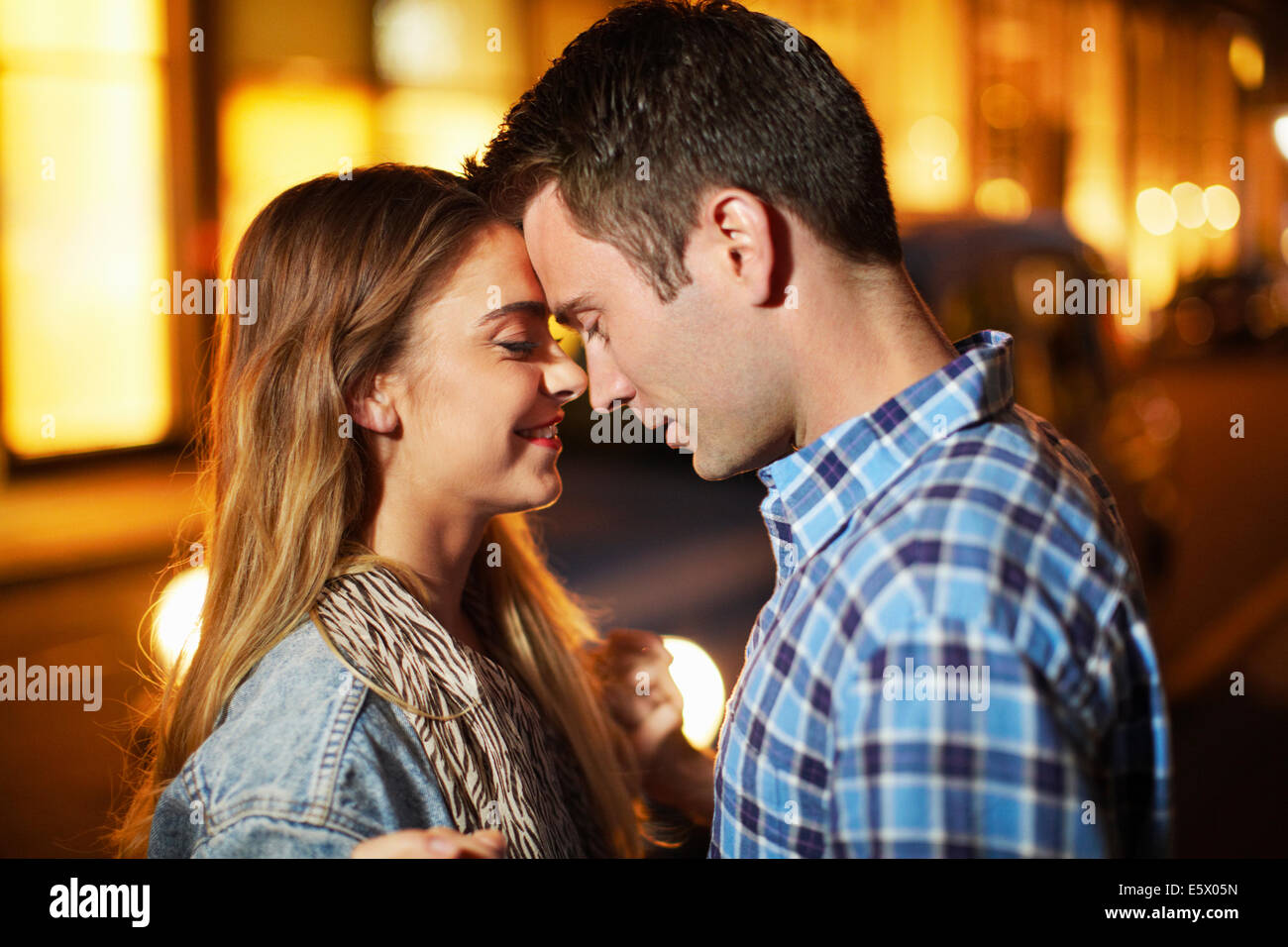 Romantic couple face to face city street at night Stock Photo