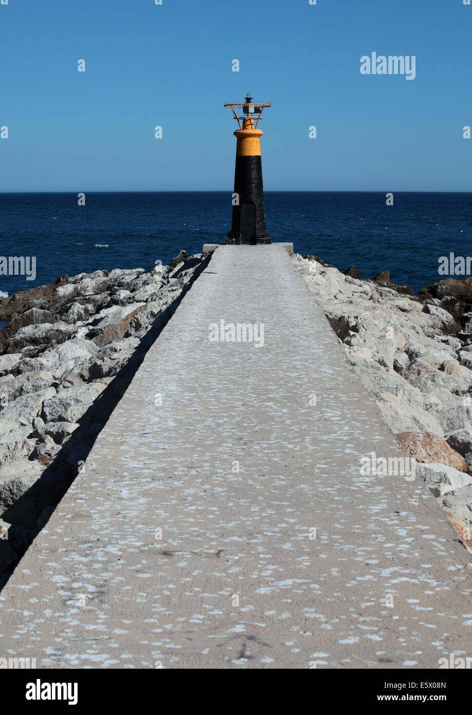 Path leading to sea navigation light Stock Photo