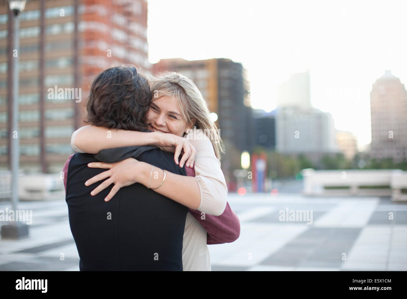 Hugging A Lod Mid adult man hugging girlfriend on rooftop parking lot Stock Photo - Alamy