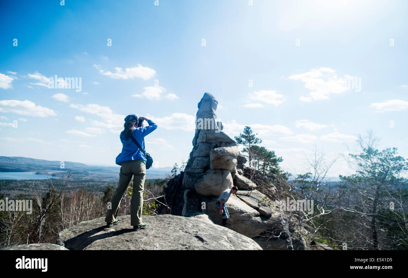 Two hikers on top of rock formation taking photographs Stock Photo - Alamy