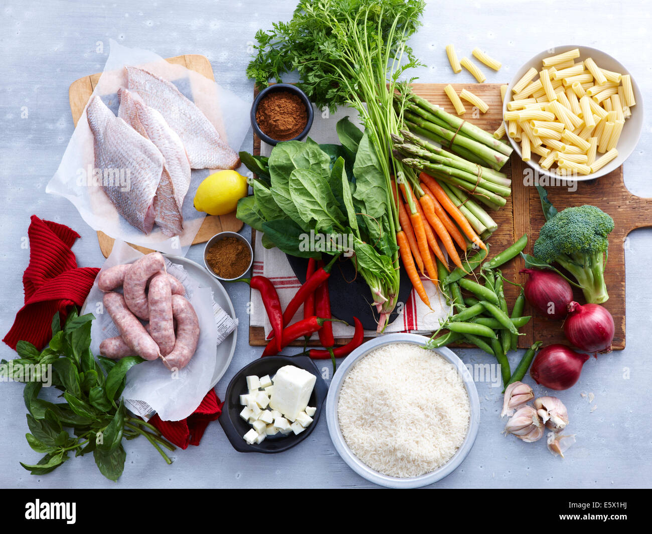 Overhead view of fish, pork sausage, feta and selection of fresh organic herbs and vegetable Stock Photo