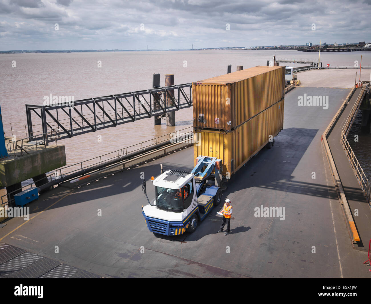 Elevated view of truck and shipping container on ramp to ship Stock Photo