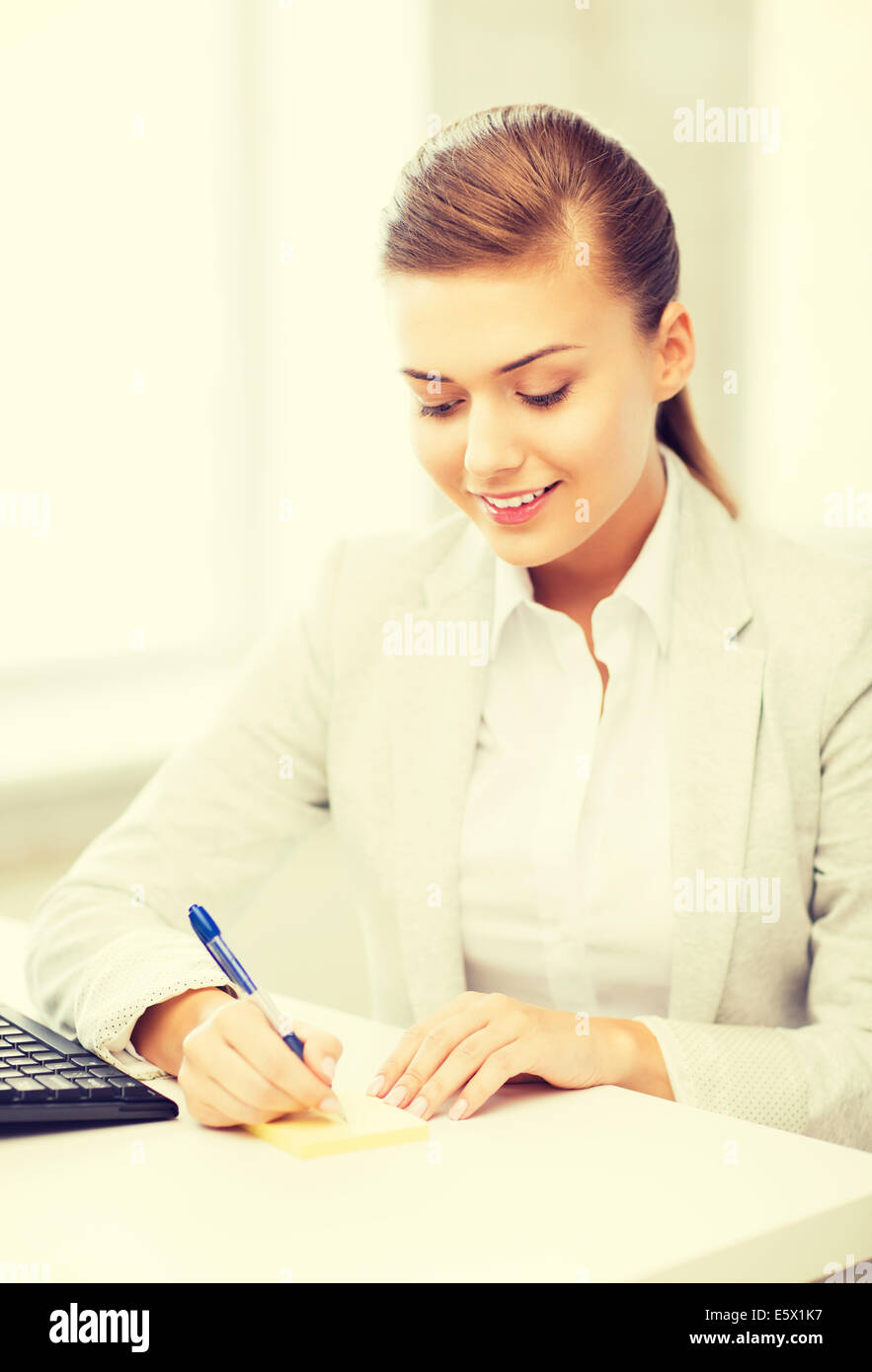 businesswoman writing on sticky note Stock Photo - Alamy